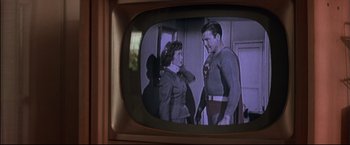 Movie still from “This Boy's Life” (1993), directed by Michael Caton-Jones – A television screen showing a man and a woman; Medium shot, Over the shoulder angle