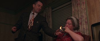 Movie still from “This Boy's Life” (1993), directed by Michael Caton-Jones – A man lighting a cigarette in front of a woman; Medium shot, Over the shoulder angle