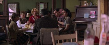 Movie still from “This Boy's Life” (1993), directed by Michael Caton-Jones – A group of people sitting around a table; Medium shot, Over the shoulder angle