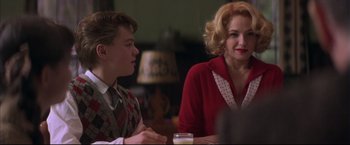Movie still from “This Boy's Life” (1993), directed by Michael Caton-Jones – Two people sitting at a dinner table talking to each other; Medium shot, Over the shoulder angle