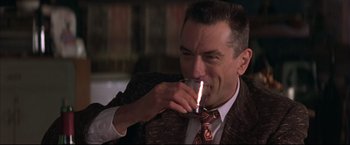 Movie still from “This Boy's Life” (1993), directed by Michael Caton-Jones – A person drinking a glass of wine; Close Up shot, Over the shoulder angle