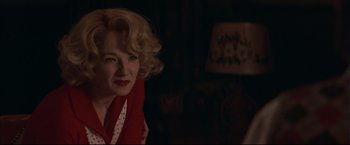 Movie still from “This Boy's Life” (1993), directed by Michael Caton-Jones – A woman with blonde hair wearing a red dress; Close Up shot, Over the shoulder angle