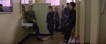 Movie still from “This Boy's Life” (1993), directed by Michael Caton-Jones – A group of young men standing around in a room; Wide shot, High angle