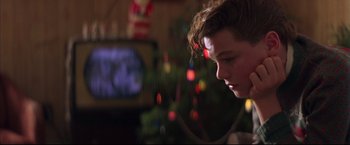 Movie still from “This Boy's Life” (1993), directed by Michael Caton-Jones – A young boy is looking at a television screen; Close Up shot, Over the shoulder angle