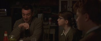 Movie still from “This Boy's Life” (1993), directed by Michael Caton-Jones – A man and a woman sitting at a dinner table; Medium shot, Over the shoulder angle