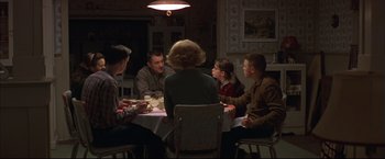 Movie still from “This Boy's Life” (1993), directed by Michael Caton-Jones – A group of people sitting around a table at a dinner table; Wide shot, High angle