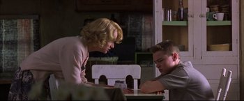 Movie still from “This Boy's Life” (1993), directed by Michael Caton-Jones – A woman and a boy sitting at a table; Medium shot, Low angle