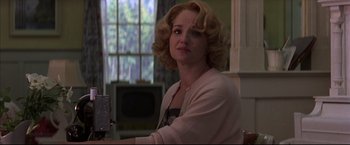 Movie still from “This Boy's Life” (1993), directed by Michael Caton-Jones – A woman sitting in front of a tv in front of a window; Close Up shot, Low angle