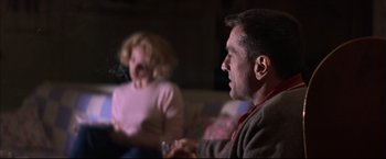 Movie still from “This Boy's Life” (1993), directed by Michael Caton-Jones – A man and a woman sitting in a living room; Medium shot, Over the shoulder angle
