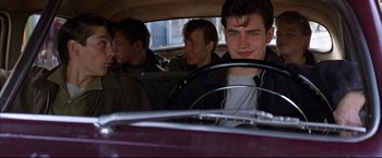 Movie still from “This Boy's Life” (1993), directed by Michael Caton-Jones – A group of young men riding in a car; Medium shot, Over the shoulder angle