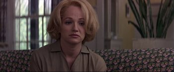 Movie still from “This Boy's Life” (1993), directed by Michael Caton-Jones – A woman sitting on a couch with her eyes wide open; Close Up shot, Over the shoulder angle