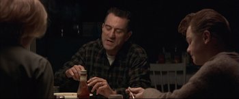 Movie still from “This Boy's Life” (1993), directed by Michael Caton-Jones – A man sitting at a table with a bottle of ketchup; Medium shot, Over the shoulder angle