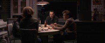 Movie still from “This Boy's Life” (1993), directed by Michael Caton-Jones – A group of people sitting at a table eating food; Wide shot, High angle