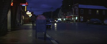 Movie still from “This Boy's Life” (1993), directed by Michael Caton-Jones – A street corner at night with cars parked on the side of the road; Wide shot, Low angle