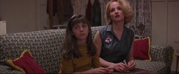 Movie still from “This Boy's Life” (1993), directed by Michael Caton-Jones – A woman sitting next to a young girl on a couch; Medium shot, Low angle