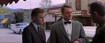 Movie still from “This Boy's Life” (1993), directed by Michael Caton-Jones – A man and a young boy standing next to each other on the street; Medium shot, Low angle