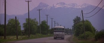 Movie still from “This Boy's Life” (1993), directed by Michael Caton-Jones – A bus driving down a road with a mountain in the background; Extreme Wide shot, Low angle