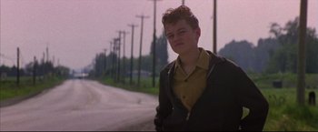 Movie still from “This Boy's Life” (1993), directed by Michael Caton-Jones – A man standing on the side of a road; Medium shot, Low angle