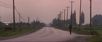 Movie still from “This Boy's Life” (1993), directed by Michael Caton-Jones – A person walking down a street near power lines; Wide shot, Low angle