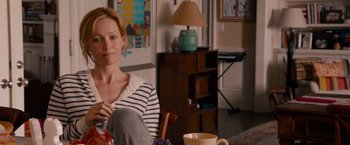 Movie still from “This Is 40” (2012), directed by Judd Apatow – A woman sitting on a chair in a living room; Medium shot, Over the shoulder angle