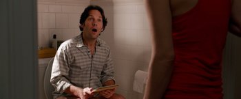 Movie still from “This Is 40” (2012), directed by Judd Apatow – A man sitting in a bathroom while holding a book; Medium shot, Over the shoulder angle