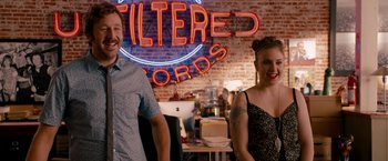 Movie still from “This Is 40” (2012), directed by Judd Apatow – A man and a woman standing next to each other in front of a neon sign; Medium shot, Over the shoulder angle