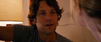 Movie still from “This Is 40” (2012), directed by Judd Apatow – A person wearing a gray t - shirt; Close Up shot, Over the shoulder angle