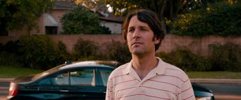 Movie still from “This Is 40” (2012), directed by Judd Apatow – A person standing near a parked car; Close Up shot, Over the shoulder angle