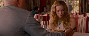 Movie still from “This Is 40” (2012), directed by Judd Apatow – A woman sitting at a table with a plate of food; Close Up shot, Over the shoulder angle