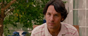 Movie still from “This Is 40” (2012), directed by Judd Apatow – A person sitting in a chair near a tree; Close Up shot, Over the shoulder angle