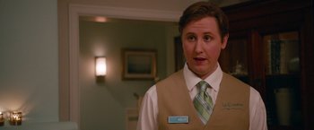 Movie still from “This Is 40” (2012), directed by Judd Apatow – A man in a vest and tie standing in front of a wall; Close Up shot, Over the shoulder angle