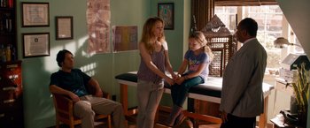 Movie still from “This Is 40” (2012), directed by Judd Apatow – Two young girls sitting on a table in a living room; Medium shot, Over the shoulder angle