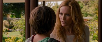 Movie still from “This Is 40” (2012), directed by Judd Apatow – A woman talking to another woman in a room with trees in the background; Close Up shot, Over the shoulder angle