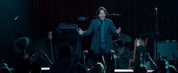 Movie still from “This Is 40” (2012), directed by Judd Apatow – A man that is singing on a microphone; Medium shot, Over the shoulder angle