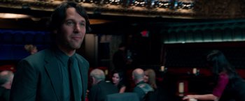 Movie still from “This Is 40” (2012), directed by Judd Apatow – A man standing in front of a group of people; Medium shot, Over the shoulder angle