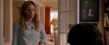 Movie still from “This Is 40” (2012), directed by Judd Apatow – A woman standing in front of a window in a room; Medium shot, Over the shoulder angle