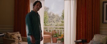 Movie still from “This Is 40” (2012), directed by Judd Apatow – A man standing in front of an open patio door; Medium shot, Over the shoulder angle