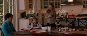 Movie still from “This Is 40” (2012), directed by Judd Apatow – A woman standing at a dining room table with a child; Medium shot, Over the shoulder angle