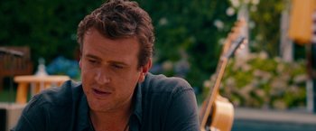 Movie still from “This Is 40” (2012), directed by Judd Apatow – A person sitting down with a guitar; Close Up shot, Over the shoulder angle