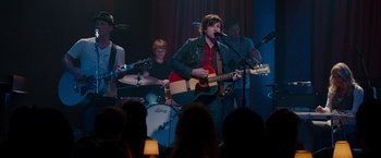 Movie still from “This Is 40” (2012), directed by Judd Apatow – A group of young people playing instruments in front of an audience; Medium shot, Over the shoulder angle
