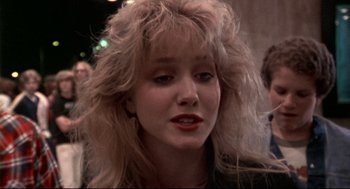 Movie still from “This Is Spinal Tap” (1984), directed by Rob Reiner – A person with long blonde hair; Close Up shot, Over the shoulder angle