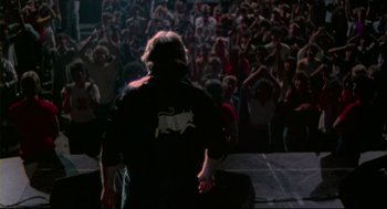Movie still from “This Is Spinal Tap” (1984), directed by Rob Reiner – A crowd of people are gathered in the dark; Wide shot, High angle