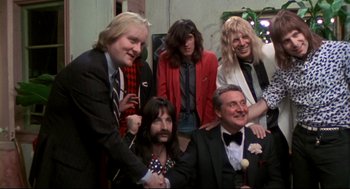 Movie still from “This Is Spinal Tap” (1984), directed by Rob Reiner – A group of people posing for a picture together; Medium shot, Overhead angle