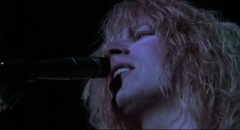 Movie still from “This Is Spinal Tap” (1984), directed by Rob Reiner – A person singing into a microphone; Extreme Close Up shot, Low angle