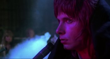 Movie still from “This Is Spinal Tap” (1984), directed by Rob Reiner – A person with a purple light on their face; Close Up shot, Low angle