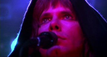 Movie still from “This Is Spinal Tap” (1984), directed by Rob Reiner – A man with a microphone in his hand; Extreme Close Up shot, Low angle