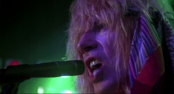 Movie still from “This Is Spinal Tap” (1984), directed by Rob Reiner – A person with a microphone in their mouth; Close Up shot, Low angle