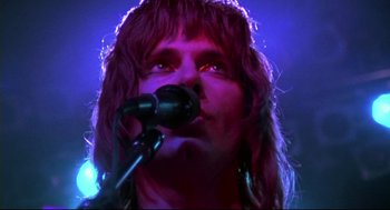Movie still from “This Is Spinal Tap” (1984), directed by Rob Reiner – A person holding a microphone; Close Up shot, Low angle