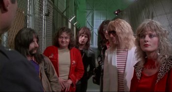 Movie still from “This Is Spinal Tap” (1984), directed by Rob Reiner – A group of people standing next to each other in a hallway; Medium shot, Over the shoulder angle