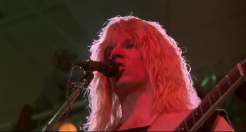 Movie still from “This Is Spinal Tap” (1984), directed by Rob Reiner – A woman with long blonde hair is singing into a microphone; Close Up shot, Low angle